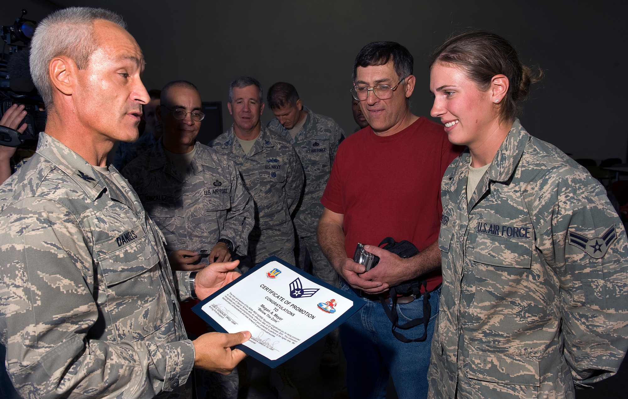 NELLIS AIR FORCE BASE, Nev. -- Col. Darren Daniels, 820th RED HORSE Squadron commander, presents Airman 1st Class Megan Meyer with a 'below-the-zone' certificate after arriving home from a deployment Oct. 5th. She and squadron members were deployed to Afghanistan for six months for engineering support. (U.S. Air Force photo by Senior Airman Brett Clashman)