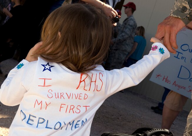 NELLIS AIR FORCE BASE, Nev. -- Audrie Waters, daughter of Tech Sgt. Brandon Mathis, holds her father's hand after his return from deployment Oct. 5th. Airmen of the 820th RED HORSE Squadron were deployed to Afghanistan for six months for engineering support. (U.S. Air Force photo by Senior Airman Brett Clashman)