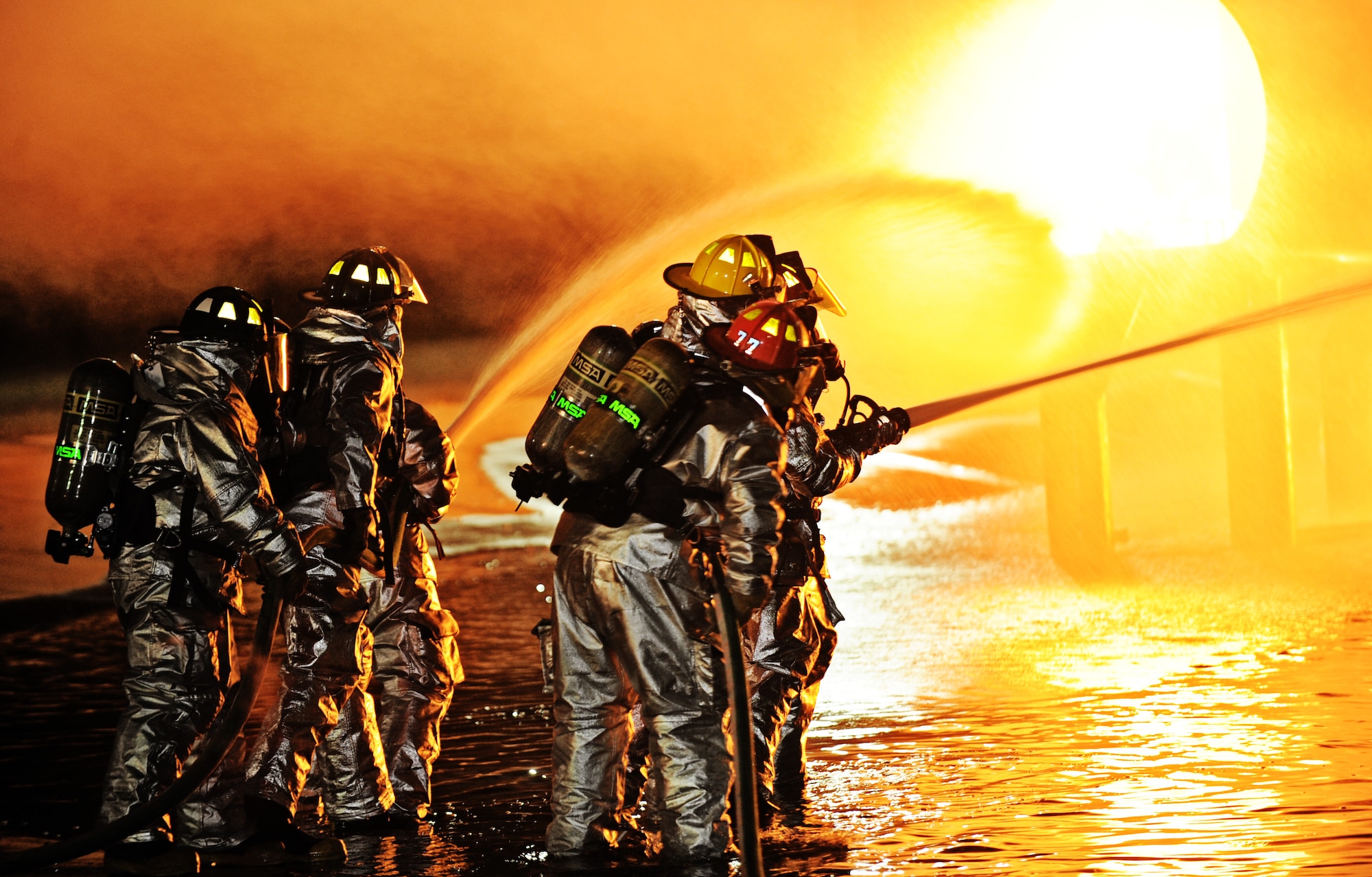 Firefighters from the 375th Civil Engineer Squadron demonstrate the proper use of the buddy system when fighting fires to on-looking families Oct. 4. In honor of Fire Safety Awareness Week, the Scott Air Force Base Fire Department provided fire safety awareness education and training throughout the week of Oct. 3-9. (U.S. Air Force photo/ Senior Airman Tristin English)