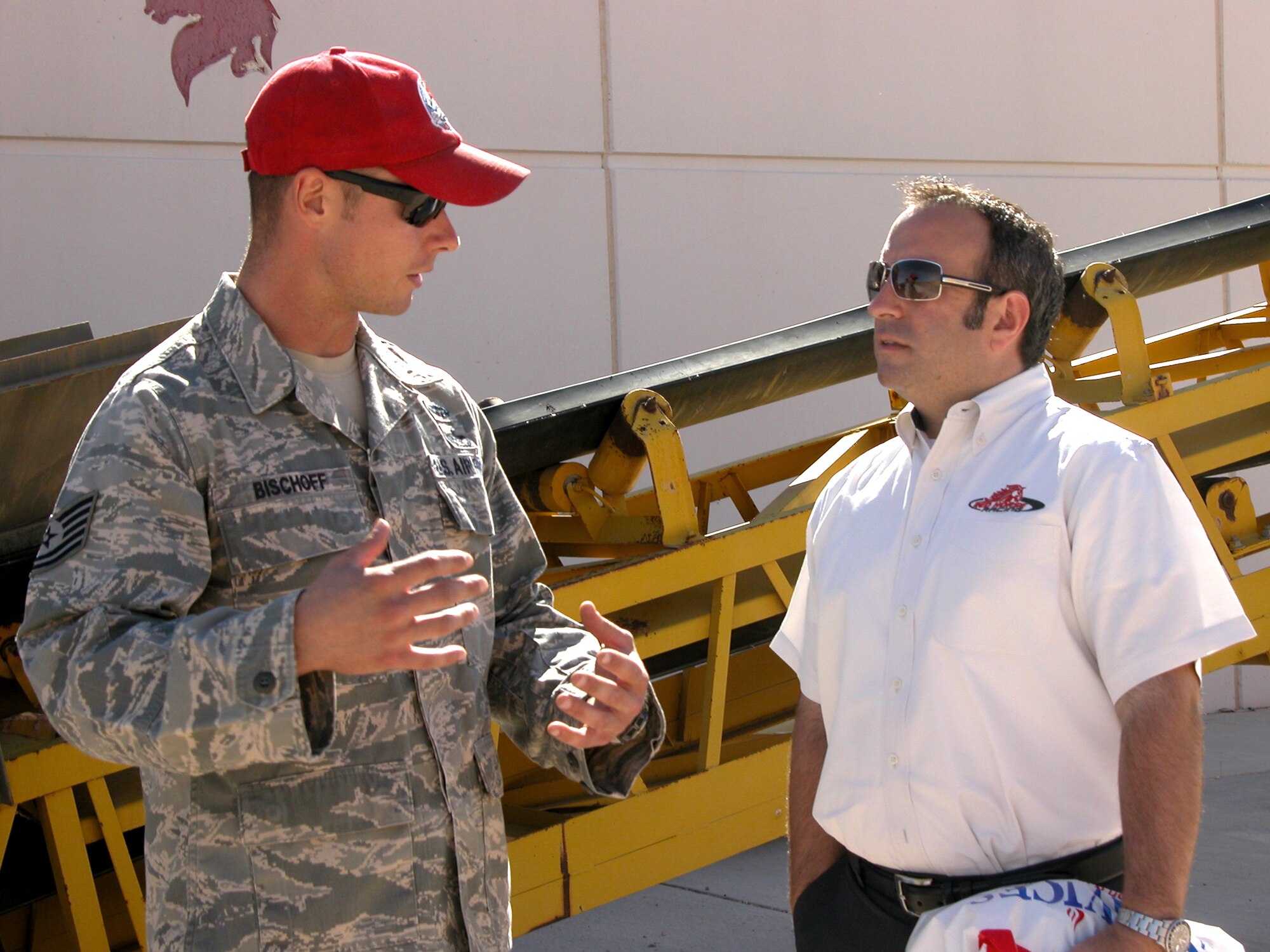 Tech. Sgt. Jason Bischoff (left) from speaks with Kevin Ray during a base visit here Sept. 24, 2010, at Nellis Air Force Base, Nev. The two "red horse" teams met for the first time after several years of anticipation. Sergeant Bischoff is assigned to the 820th RED HORSE Squadron and Mr. Ray is the Red Horse Racing team manager. (U.S. Air Force photo/Tech. Sgt. Minette Mason)