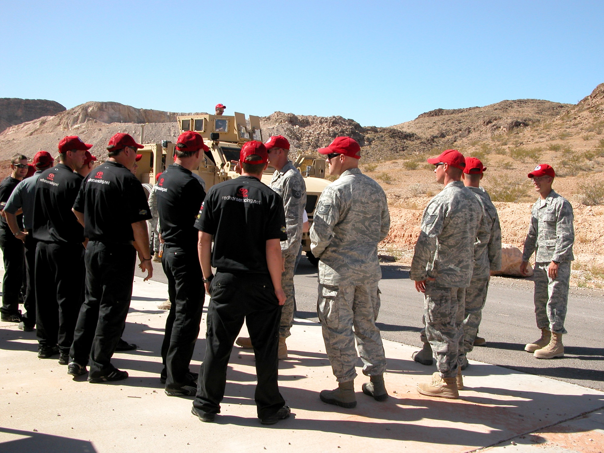 Members of the 820th RED HORSE Squadron explain to members of NASCAR's Red Horse Racing team the capabilities of a mine-resistant, ambush-protected all-terrain vehicle during a base visit Sept. 24, 2010, at Nellis Air Force Base, Nev. The two "red horse" teams met for the first time after several years of anticipation. (U.S. Air Force photo/Tech. Sgt. Minette Mason)