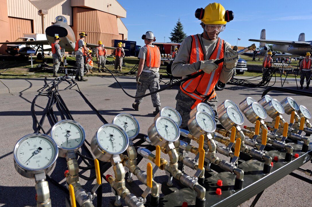 ELLSWORTH AFB, S.D. - Airman 1st Class Rawlinson Santaella, 28th Maintenance Squadron repair and reclamation technician, prepares to connect an air hose to a pneumatic manifold, Sept. 27.  The hose connects the manifold to pneumatic air bags capable of lifting up to 26 tons. The 28th Maintenance Squadron repair and reclamation section is responsible for crash recovery; they manage clean-up efforts in the event of an aircraft incident on the airfield. (U.S. Air Force photo/Staff Sgt. Marc I. Lane)
