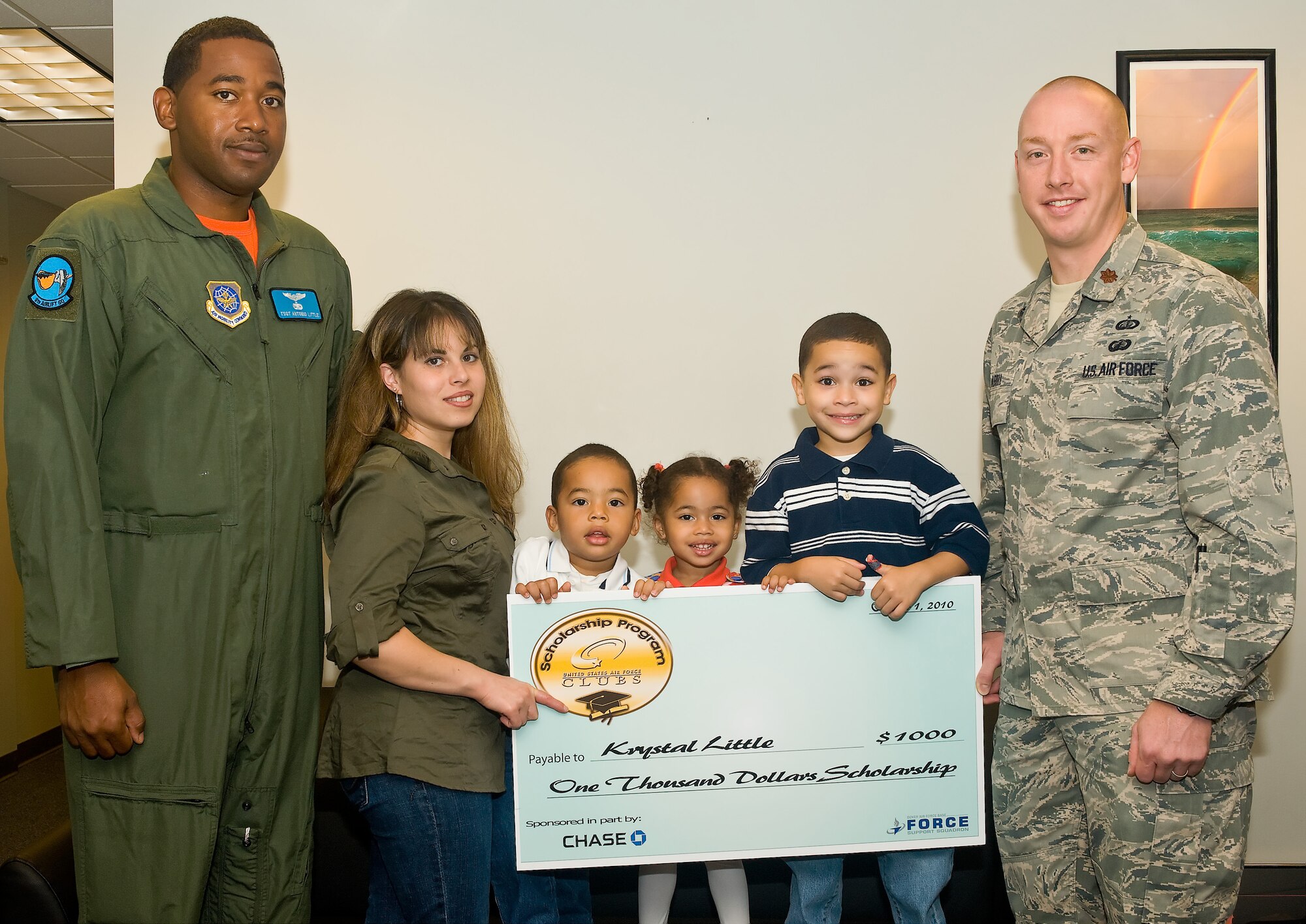 Tech. Sgt. Anthony Little, 9th Airlift Squadron, his wife Krystal, and children Conner, Brooklyn and Matthew receive a $1,000 Air Force Club Scholarship program check from Maj. Thomas Abell, 436th Force Support Squadron commander at Building 520 on Dover Air Force Base, Del., Oct. 1, 2010. Mrs. Little and Master Sgt. Jay Flack of the 436th Force Support Squadron (not pictured) were two out of the total 25 winners Air Force-wide selected from the 130 entries submitted by installations and will each receive a $1,000 scholarship. (U.S. Air Force photo by Roland Balik/Released)