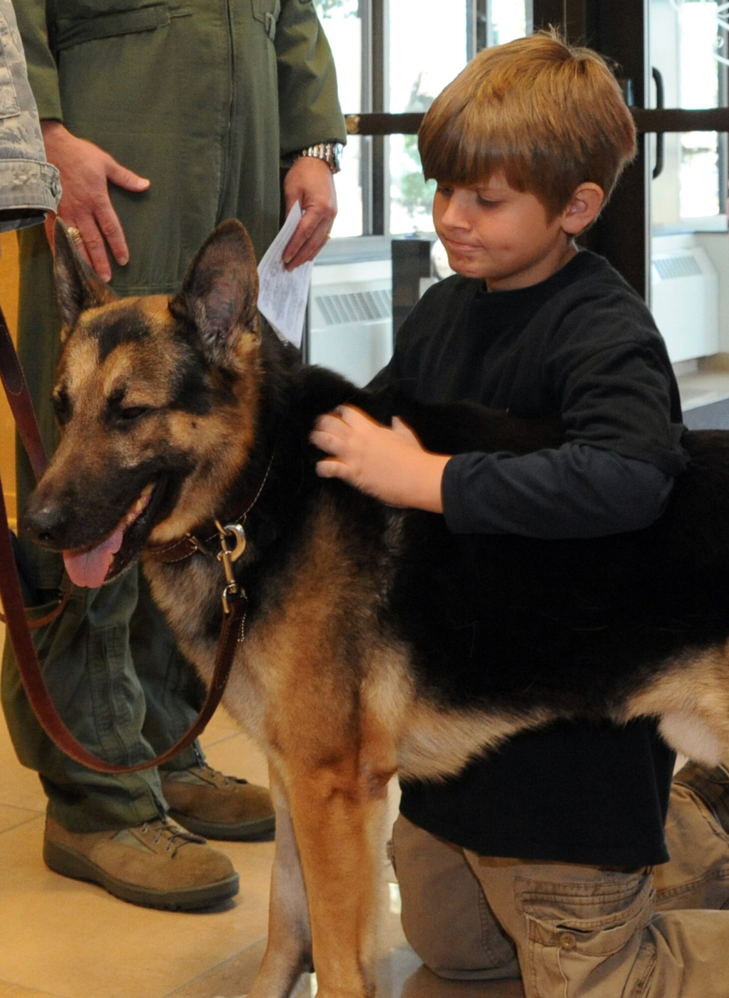 Former military working dog Nick/J252, gets a back rub from one of his new masters Oct. 6 at Heritage Hall on Grand Forks Air Force Base. Nick was stationed at Grand Forks AFB for four years before he was medically retired. During Nick’s military career, he has deployed twice in support of Operation Iraqi Freedom and also supported U.S. secret service missions protecting heads of states and the President of the United States. Nick was adopted by his former handler, Tech. Sgt. David Crawley, 319th Security Forces Squadron MWD handler. (U.S. Air Force photo by Tech. Sgt. Johnny Saldivar) 