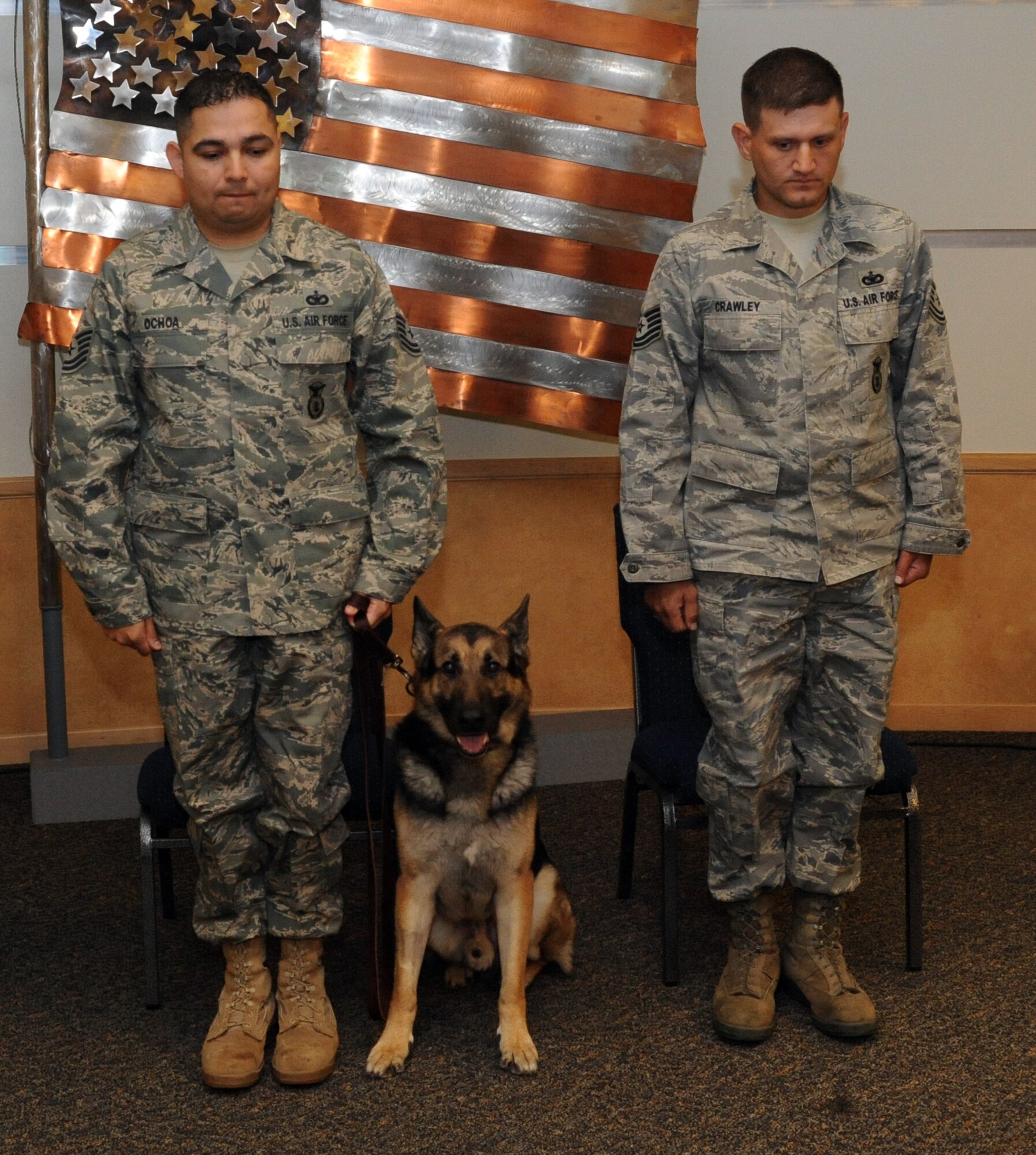 Tech. Sgt. Mark Ochoa (from left to right), 319th Security Forces Squadron kennel master, Nick/J252, a military working dog with the 319th SFS and Tech. Sgt. David Crawley, 319th SFS MWD handler, prepare to formally retire Nick, Oct. 6 at Heritage Hall on Grand Forks Air Force Base. Nick was stationed at Grand Forks AFB for four years before he was medically retired. During Nick’s military career, he has deployed twice in support of Operation Iraqi Freedom and also supported U.S. secret service missions protecting heads of states and the President of the United States. Nick was adopted by his former handler, Sergeant Crawley. (U.S. Air Force photo by Tech. Sgt. Johnny Saldivar)  
