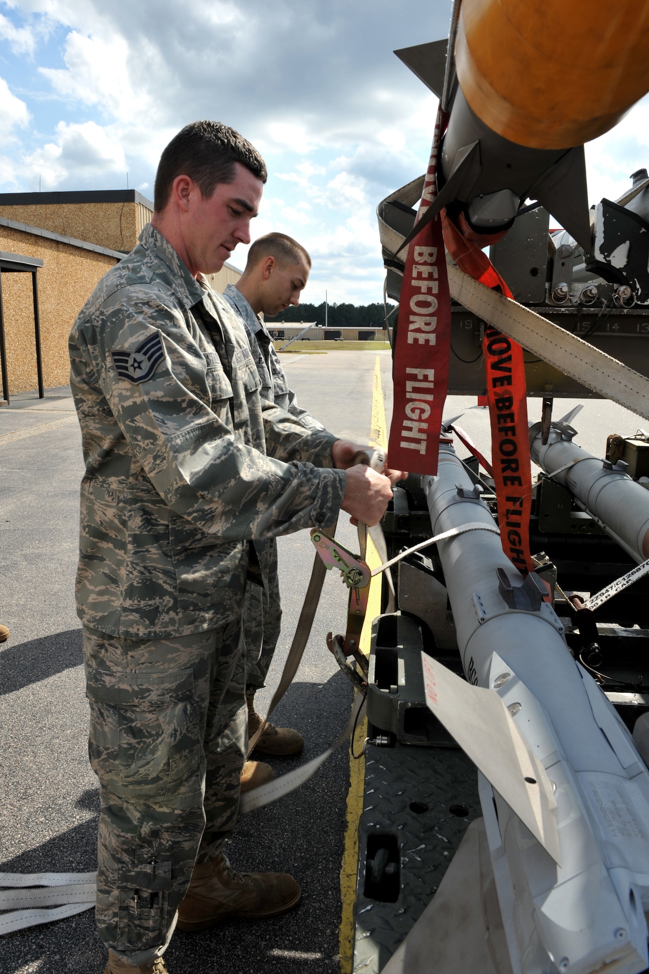 101004-F-4406D-008 SHAW AIR FORCE BASE, S.C.--    Staff Sgt. Jonathan Farmer and Staff Sgt. Patrick Stehley, 20 Equipment Maintenance Squadron precision guided munitions crew chiefs, tighten the strap around the Air Intercept Missile-9X to secure it in place on a trailer Oct. 4, 2010. The ammo shop plays a key role in ensuring missiles are built, pre-inspected and accounted for before they are loaded on trailers and delivered to the flightline. (U.S. Air Force photo/ Airman 1st Class Tabatha L. Duarte(Released)