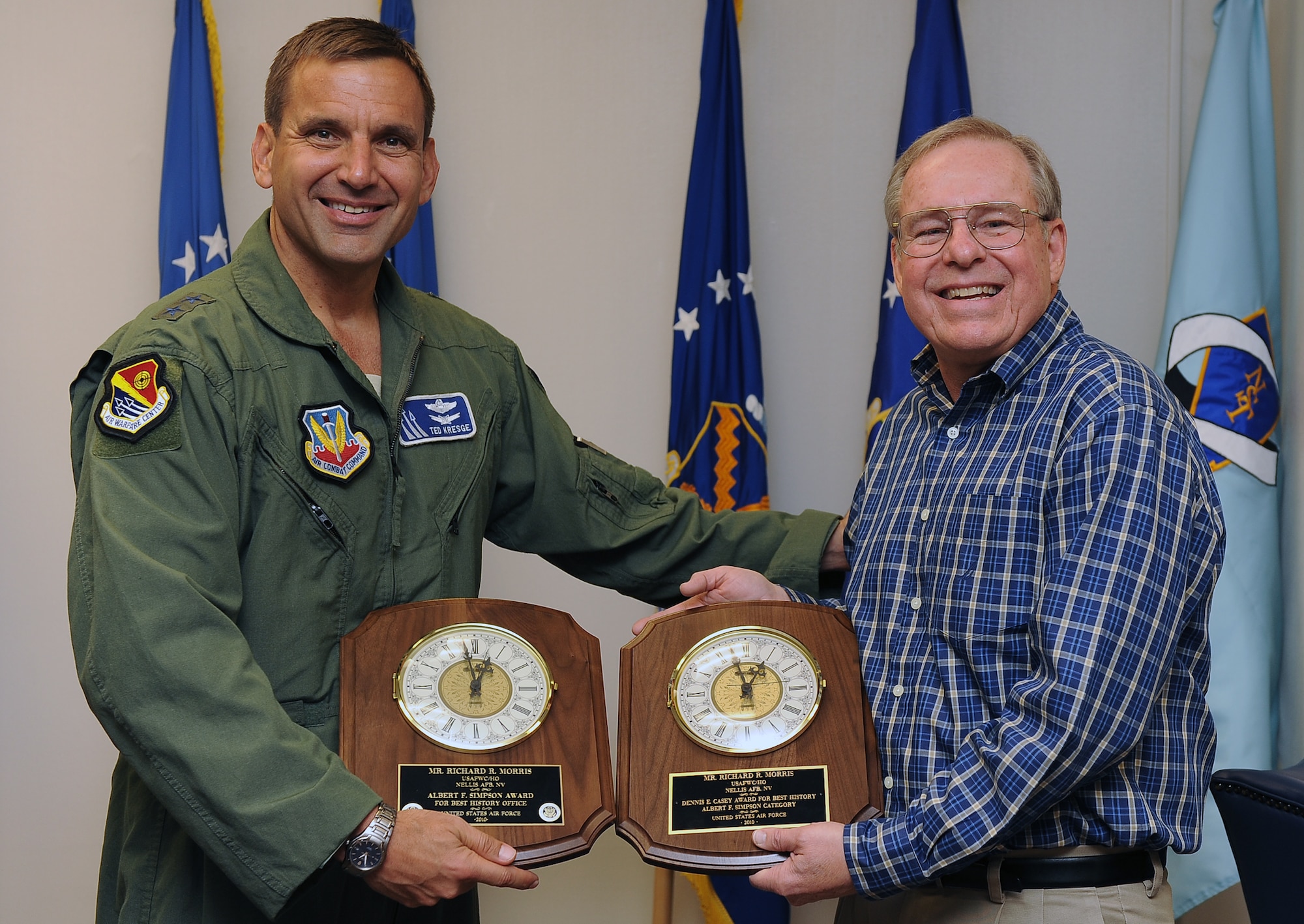 NELLIS AIR FORCE BASE, Nev. – Maj. Gen. Ted Kresge, U.S. Air Force Warfare Center commander presents Mr. Richard Morris, U.S. Air Force Warfare Center historian, with the Albert F. Simpson Award and Dennis E. Casey Award, during a ceremony Sept. 04, at the Warfare Center. The Albert F. Simpson Award recognizes the best history office at the NAF, Center, or laboratory level, and the Dennis E. Casey Award recognizes the single best periodic history.