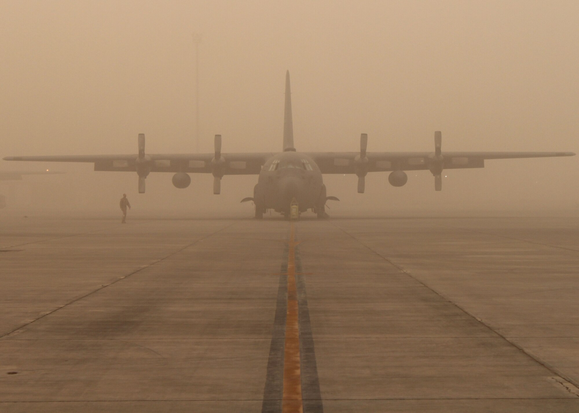 A lone Airman checks for foreign objects and debris on the ramp during a dusty dawn Oct. 3, 2010, Joint Base Balad, Iraq.  Even though summer and early fall dust storms have been a fairly frequent visitor to Balad, Airmen continue to ensure the flightline and all aircraft are ready to go to support the mission of Operation New Dawn. (U.S. Air Force photo/ Tech. Sgt. Stacy Fowler)