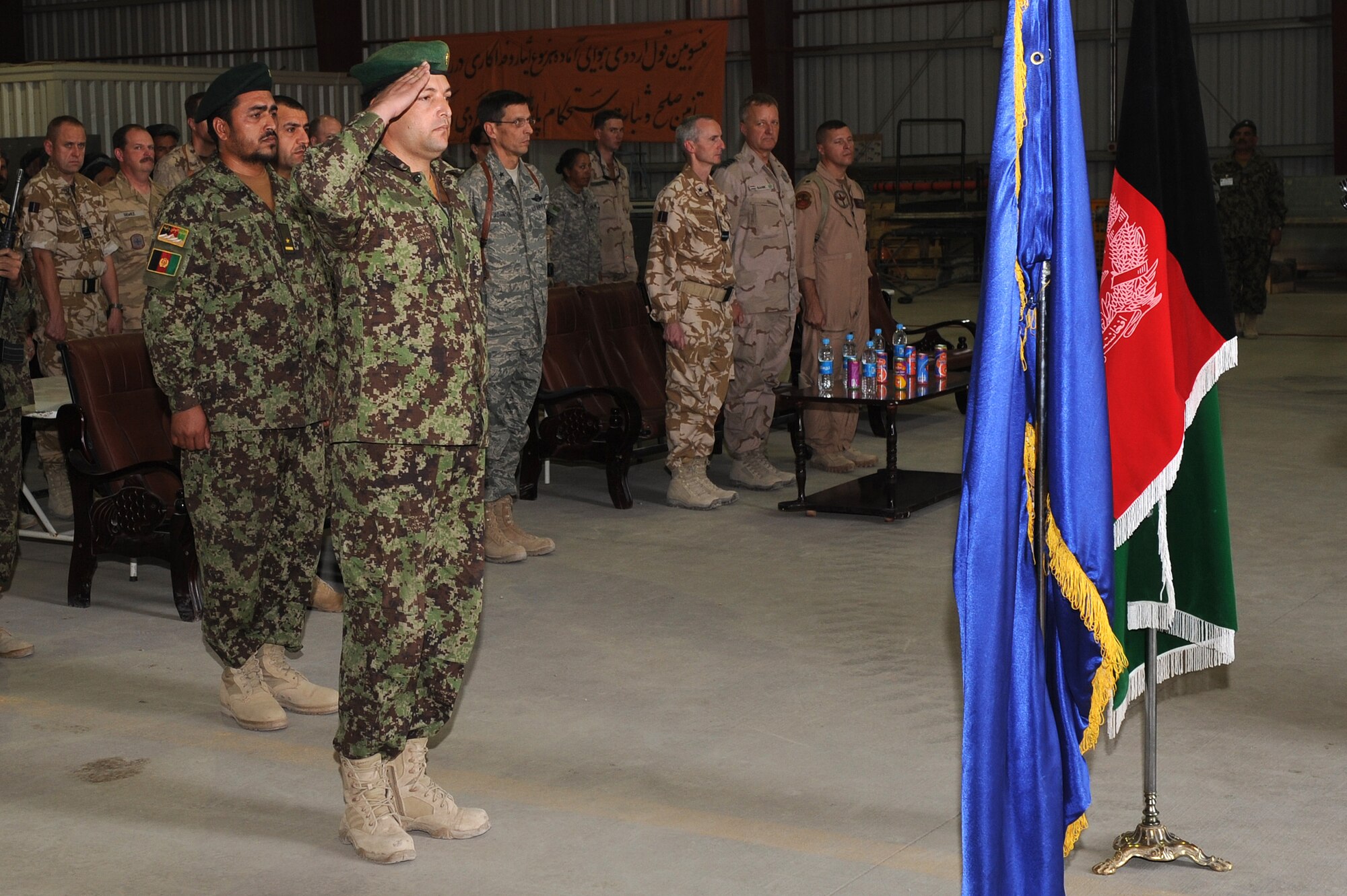 An Afghan Airman salutes the flag of the Islamic Republic of Afghanistan during a celebration marking the first anniversary of the activation of the Kandahar Air Wing, Oct. 5, 2010, at Kandahar Airfield, Afghanistan.  The KAW currently maintains and operates five Mi-17 helicopters and also supports transient fixed wing aircraft. (U.S. Air Force photo by Tech. Sgt. Chad Chisholm/Released)