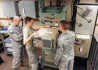 MINOT AIR FORCE BASE, N.D. -- Airman 1st Class Brian Ellis, 91st Missile Maintenance Squadron missile radio technician, inspects a cable connector as Senior Airman Nathan Hendricks, 91st MMXS missile radio technician, secures a cable to the back of the terminal electronics unit while being observed by Staff Sgt. Matthew Owen, 91st MMXS missile radio team chief, here Oct.4. The TEU is a part of the minuteman minimum essential emergency communications network program. Programs like these are crucial to the mission of all Airmen assigned to Air Force Global Strike Command. (U.S. Air Force photo by Staff Sgt. Keith Ballard)