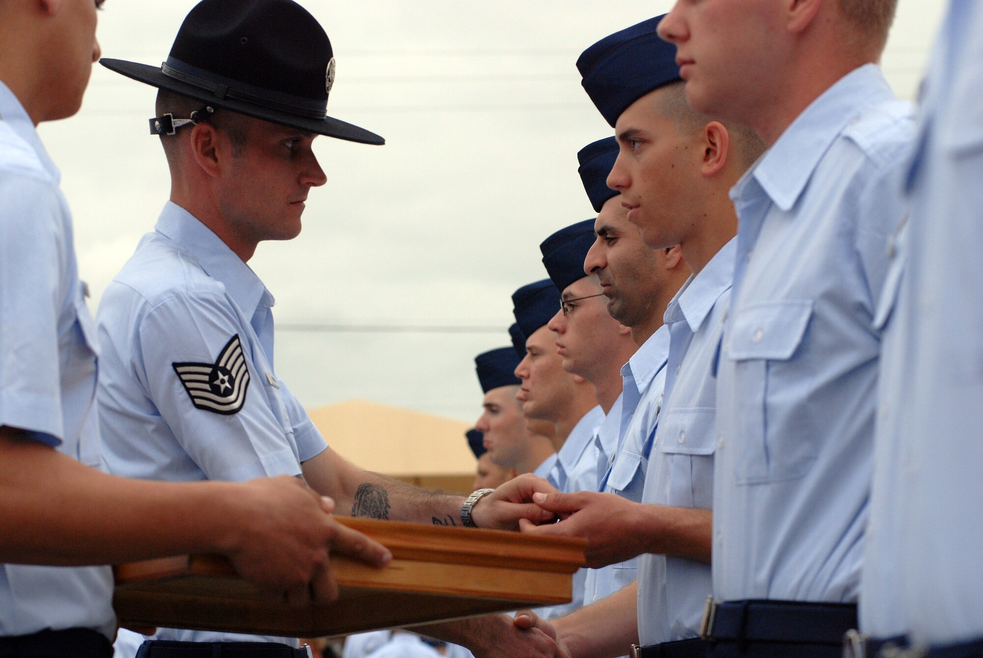 A military training instructor hands out Airmen's Coins during a coining ceremony at Lackland Air Force Base, Texas. The ceremony is traditionally held the day before basic trainees graduate from Air Force Basic Military Training. (U.S. Air Force photo)