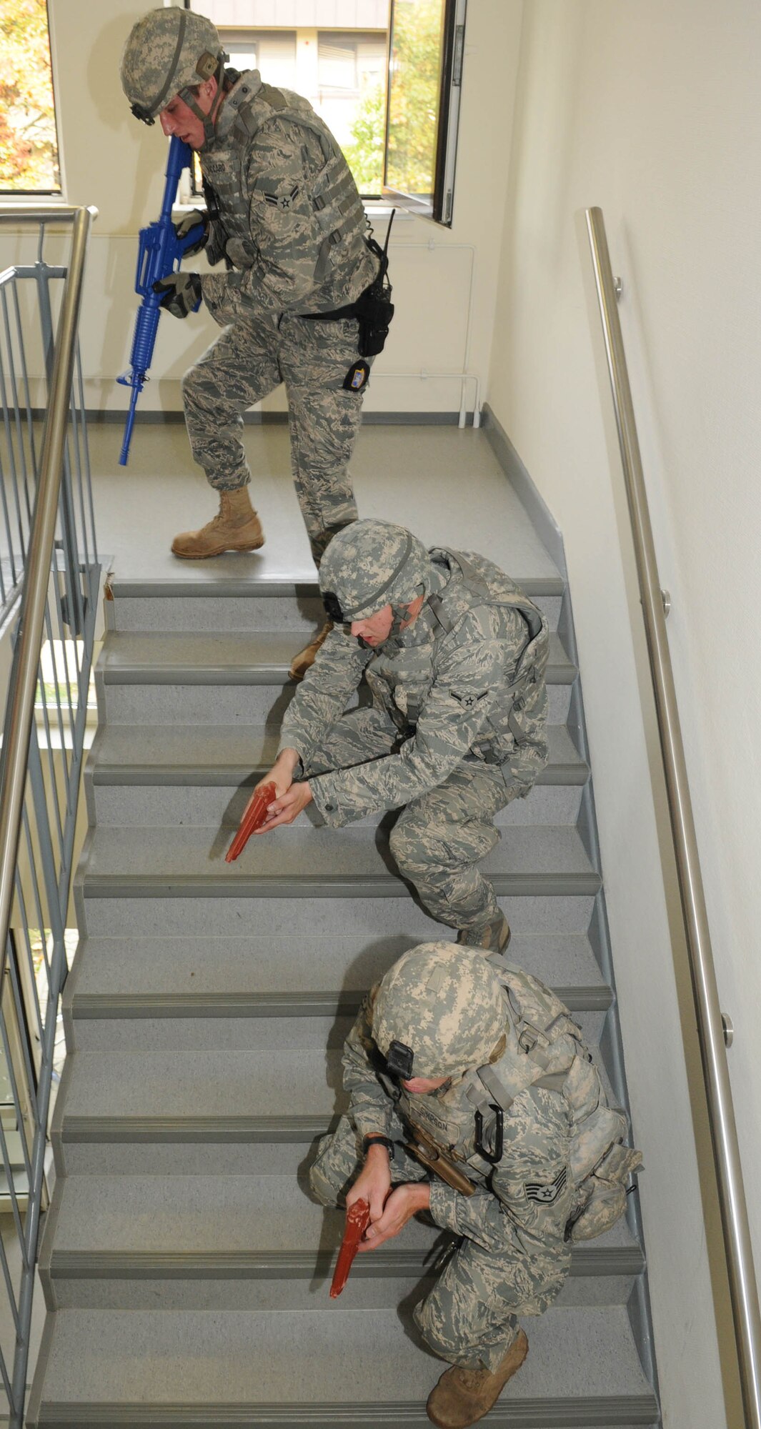 SPANGDAHLEM AIR BASE, Germany – Airman 1st Class Anthony Vaccaro and Airman Keith Struck 52nd Security Forces Squadron patrolmen, and Staff Sgt. David Simpson, 52nd SFS K-9 handler, move down a stairwell during active shooter training Oct. 4.  The training was designed to instruct security forces members how to quickly find and stop suspects who are shooting at people.  (U.S. Air Force photo/Staff Sgt. Logan Tuttle)