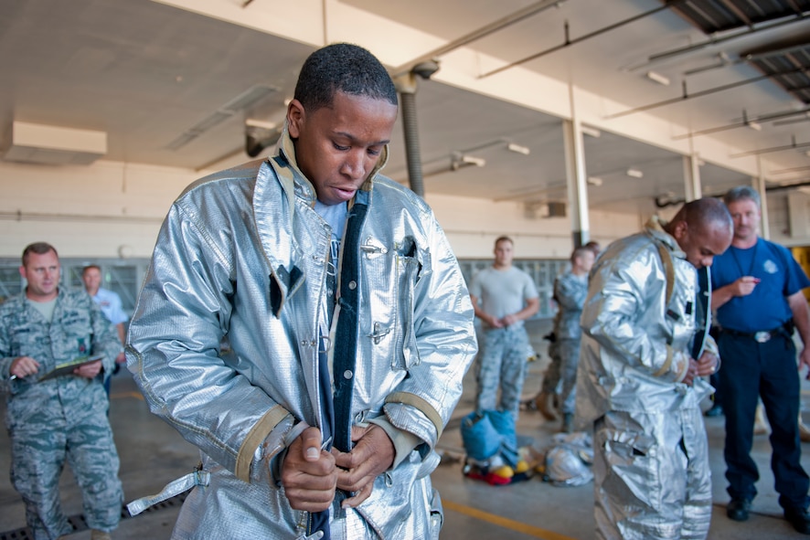 MOODY AIR FORCE BASE, Ga. -- Staff Sgt. Clarence Graves, 23rd Logistics Readiness Squadron fuels facilities supervisor, races against Col. Neal Robinson, 23rd Maintenance Group commander, in a bunker drill Oct. 4 at the 23rd Civil Engineer Squadron fire station. The object of the competition was for each team member to put their gear on as quickly as possible. After completion, 23rd CES personnel inspected each member to ensure all their snaps and buttons were fastened and their helmet and gloves were on securely. (U.S. Air Force photo/Senior Airman Jamal D. Sutter)