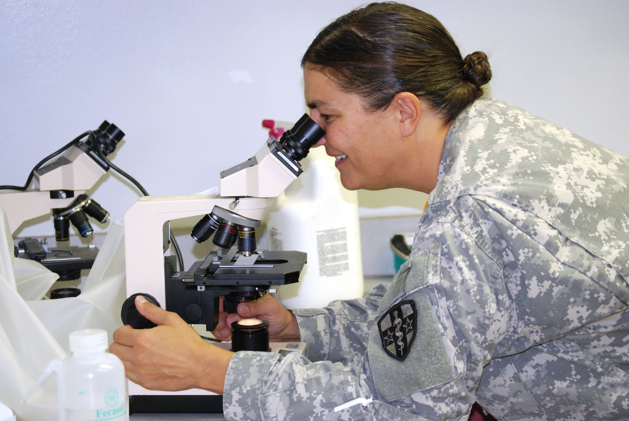 Army Lt. Col. Shannon Sutherland looks at a specimen through a microscope Oct. 5 at Sheppard Air Force Base's Veterinary Clinic. The Army veterinarian said people who have orders to PCS overseas need to remember their pets have to go through an outprocessing checklist before they are cleared to go to a foreign country. (U.S. Air Force photo/John Ingle)