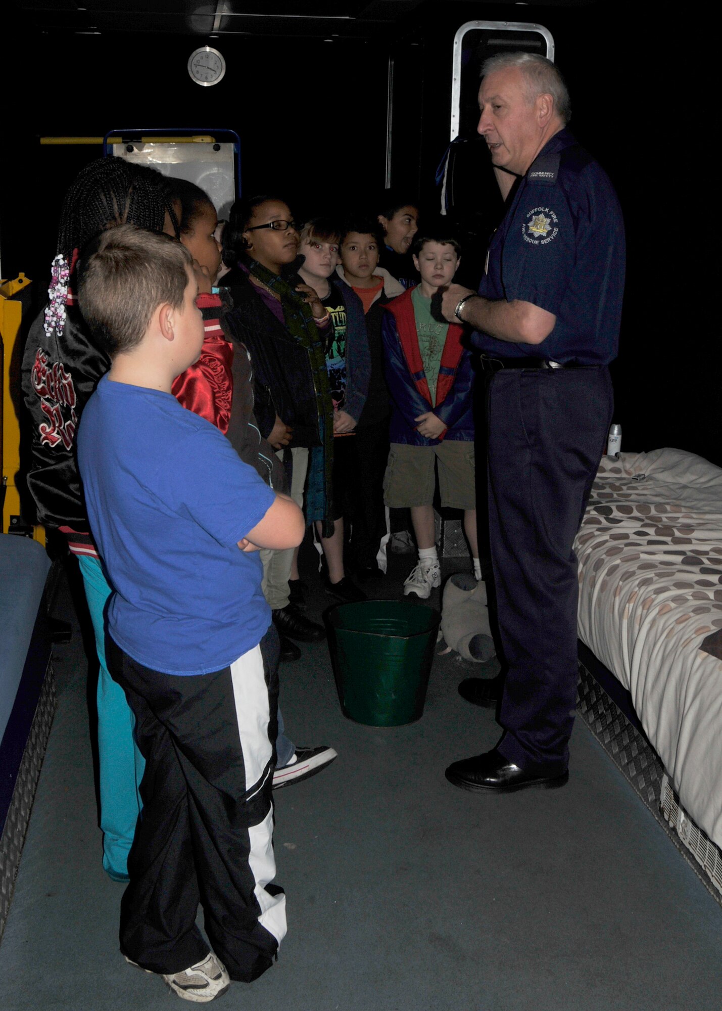 ROYAL AIR FORCE LAKENHEATH England - Community Fire Safety Officer John Clouting of the Suffolk Fire and Rescue Service Fire Experience Unit (right), briefs a group of RAF Lakenheath Intermediate School students on possible fire hazards in a mock bedroom display during National Fire Prevention Week on Oct. 5. In the demonstration, the students learned how often to change smoke alarm batteries, not to put aerosol cans on heaters, not to leave televisions or other electronics on overnight and other useful fire prevention information. (U.S. Air Force photo/Airman 1st Class Tiffany M. Deuel)