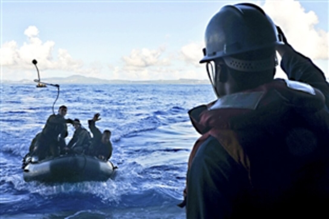 U.S. Navy Seaman Brandon Cash assists Marines as they return to the USS Essex after conducting a training exercise near Okinawa, Japan, Oct. 3, 2010. The Marines are assigned to 31st Marine Expeditionary Unit.