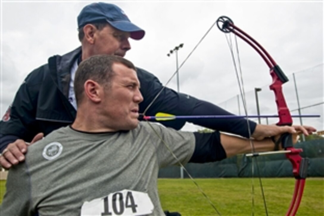 Retired U.S. Army Cpl. Kevin Stoneormer teaches former Army Spc. Erik Hjeltnes to draw and fire a bow with his teeth during the U.S. Olympic Committee Paralympic Military Sports Camp at Naval Medical Center San Diego, Oct. 5, 2010. More than 60 injured troops from U.S., British, and Israeli armed forces participated in the four-day event to introduce paralympic sports to troops and veterans with physical injuries. Stoneormer is a 2004 and 2008 Team U.S.A. paralympic gold medalist.