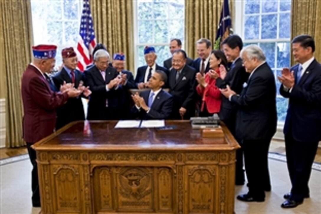 President Barack Obama and his guests applaud after the signing of S.1055, a bill to grant the Congressional Gold Medal collectively to the 100th Infantry Battalion and the 442nd Regimental Combat Team, to recognize their dedicated service during World War II, in the Oval Office, Washington, D.C., Oct. 5, 2010. Guests included VA Secretary Eric K. Shinseki, far right, and U.S. Sen. Daniel K. Inouye of Hawaii, a 442nd member, at Obama's right.