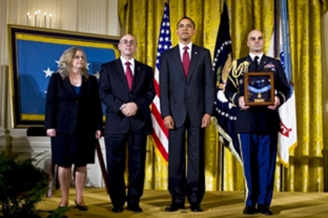 President Barack Obama stands with Phil and Maureen Miller, parents of U.S. Army Staff Sgt. Robert J. Miller, as the citation is read as part of the ceremony to posthumously award the Medal of Honor to their son in the East Room of the White House, Oct. 6, 2010. Miller was cited for heroic actions in Afghanistan on Jan. 25, 2008.