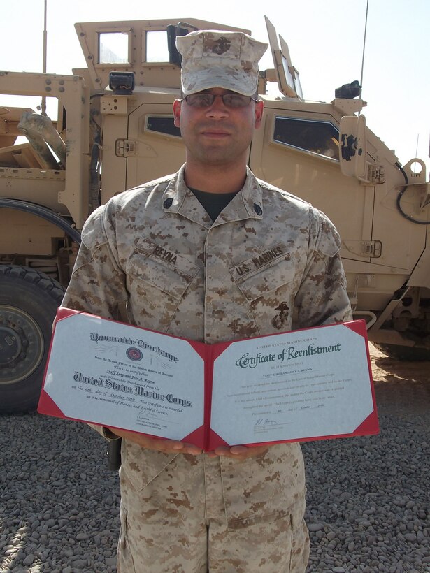Staff Sgt. Jose Reyna, company gunnery sergeant for Transportation Support Company A, Combat Logistics Battalion 5, 1st Marine Logistics Group (Forward) receives his enlistment certificate after reciting an oath dedicating four more years of active duty service, Oct. 6.