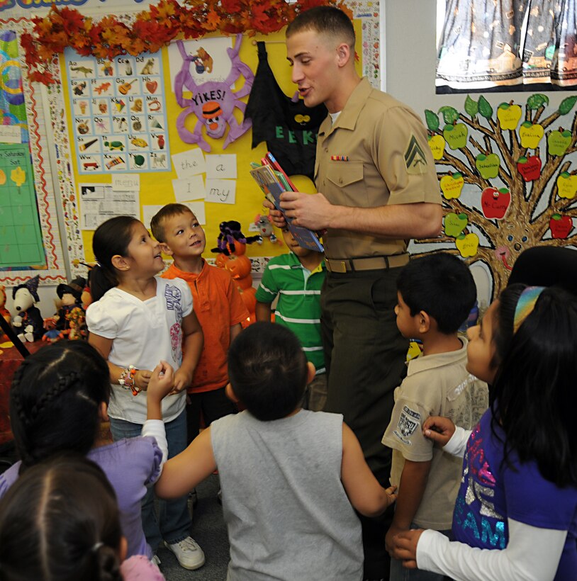 Cpl. Seth Jacob, Marine Attack Squadron 214 aviation ordnanceman, holds books that kindergarten students chose at C.W. McGraw Elementary School in Yuma, Ariz., Oct. 6, 2010. The Blacksheep adopted the school as part of the Adopt-a-School Program. They plan to visit the school every Wednesday to promote literacy and scholastic achievement, and engage in various activities with students from every grade level at the school.