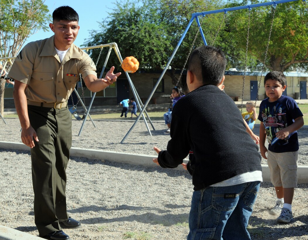 Lance Cpl. David Vasquez, Marine Attack Squadron 214 administration clerk, plays catch with kindergarten students at C.W. McGraw Elementary School in Yuma, Ariz., Oct. 6, 2010. The Blacksheep adopted the school as part of the Adopt-a-School Program. They plan to visit the school every Wednesday to promote literacy and scholastic achievement, and engage in various activities with students from every grade level at the school.