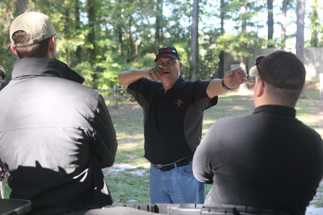 John Fuller, Wounded Warrior Archery coach, instructs Marine Corps wounded warriors on the proper technique in drawing back the bowstring during the Archery Wounded Warrior Sports Camp at the archery range aboard Marine Corps Base Camp Lejeune, Oct. 6 through 10. One of multiple summer sports camps designed to prepare wounded warriors for the upcoming Wounded Warrior Games in Colorado Springs, Colo., in May 2011, the archery camp draws wounded warriors from across the country to learn the proper procedures of archery.