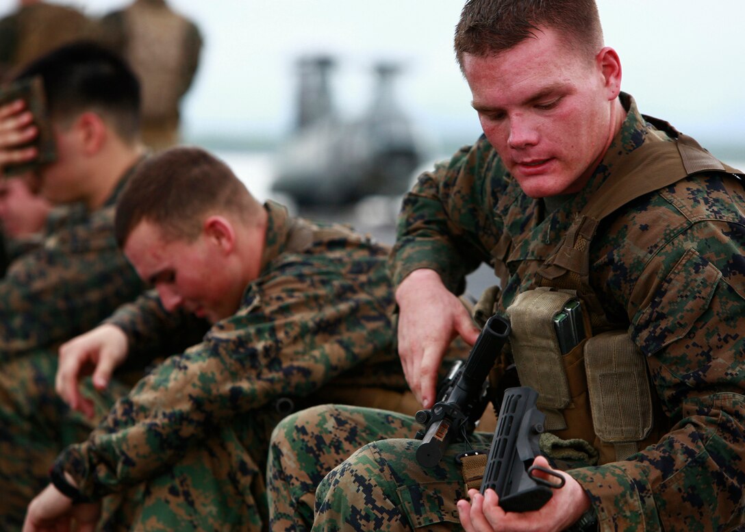 U.S. Marine Cpl. Jacob J. Bottoms, from Jacksonville, Fla., from Company A, 2nd Assault Amphibian Battalion, attached to Special-Purpose Marine Air-Ground Task Force Continuing Promise 2010, cleans his M4 Carbine during a ten-minute break while conducting a six mile hump, aboard amphibious assault ship USS Iwo Jima (LHD7), off the coast of Chiriqui Grande, Panama, Oct. 7, 2010. Service members and civilians are deployed in support of CP10 providing medical, dental, veterinary, engineering assistance and subject-matter exchanges to Caribbean, Central and South American nations.