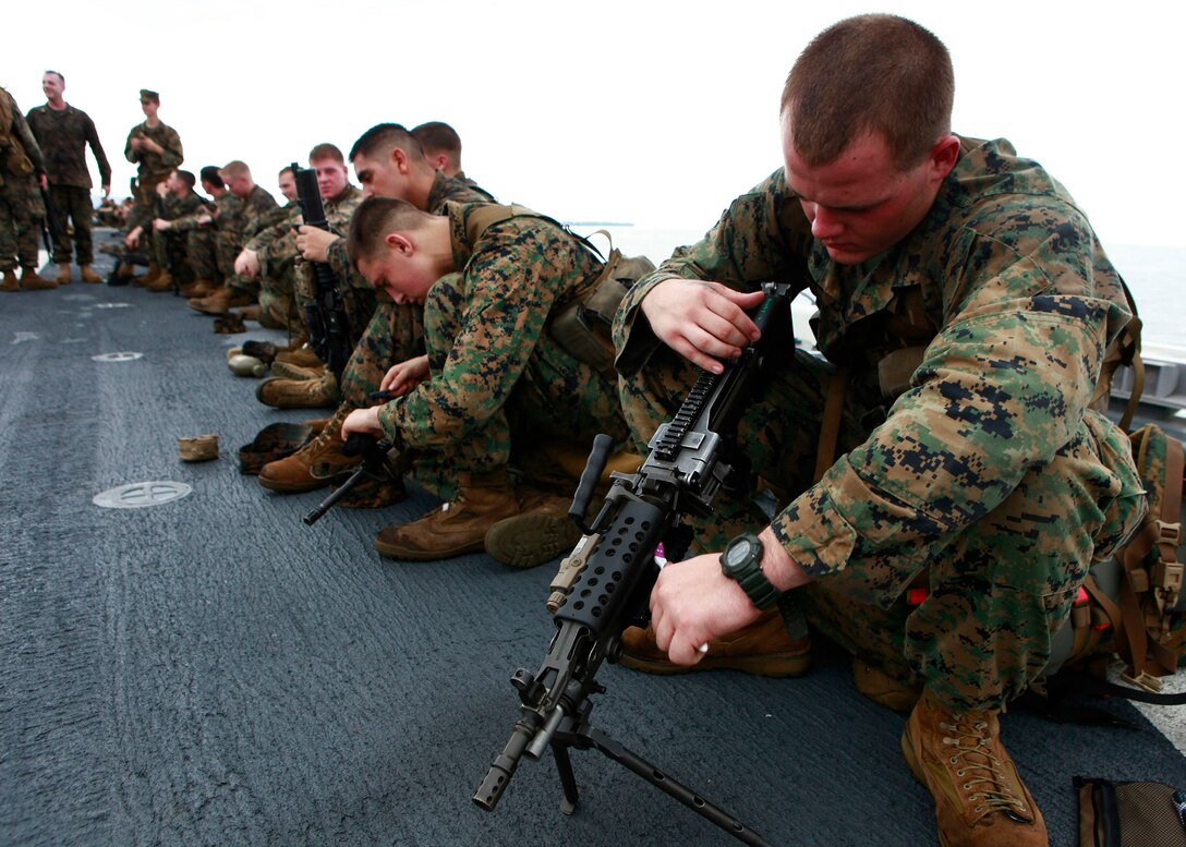 U.S. Marines and Sailors from 2nd Assault Amphibian Battalion, attached to Special-Purpose Marine Air-Ground Task Force Continuing Promise 2010, take a 10-minute break to check gear and clean weapons, while conducting a six mile hump, aboard amphibious assault ship USS Iwo Jima (LHD7), off the coast of Chiriqui Grande, Panama, Oct. 7, 2010. Service members and civilians are deployed in support of CP10 providing medical, dental, veterinary, engineering assistance and subject-matter exchanges to Caribbean, Central and South American nations.