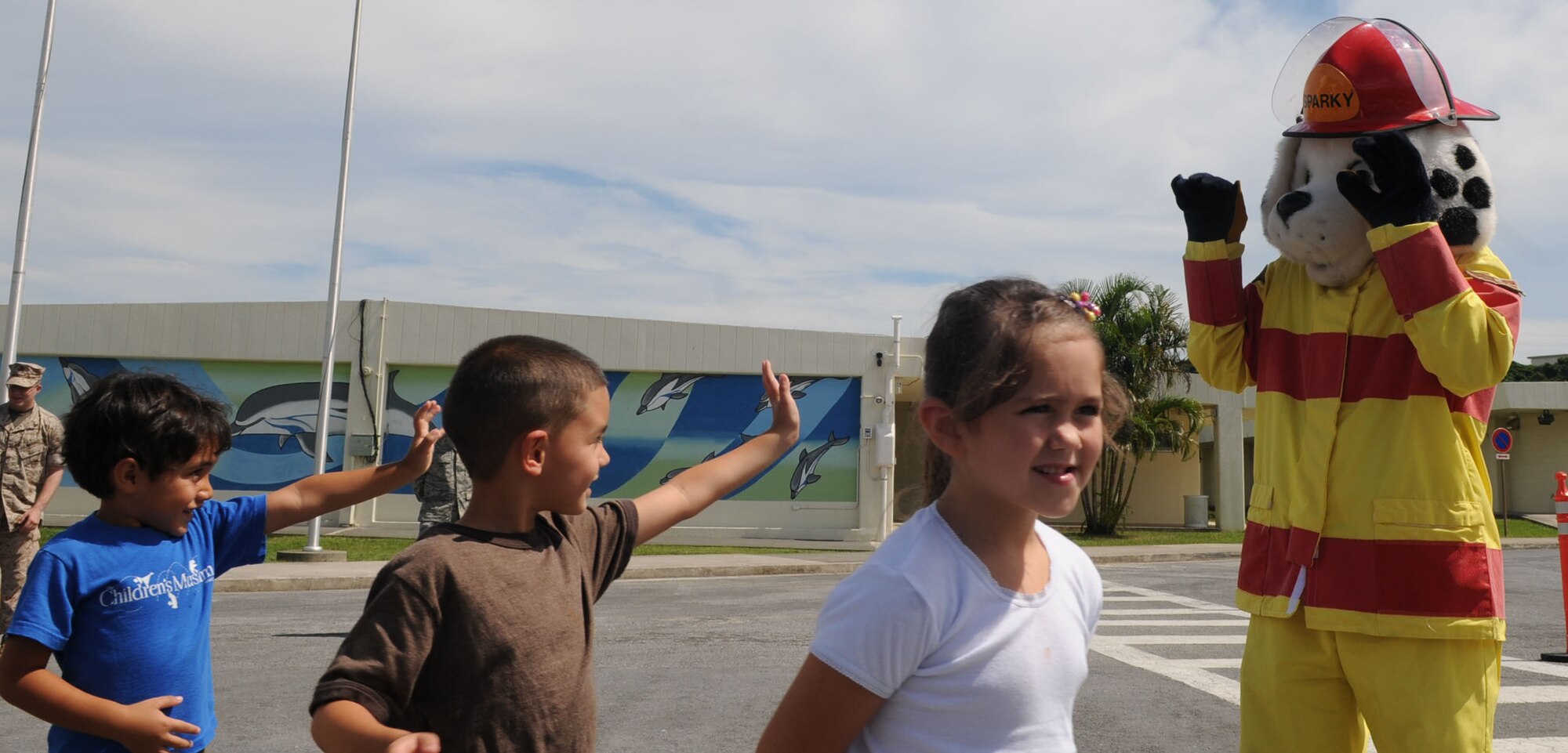 Children from Kadena Elementary School say goodbye to Sparky the Fire Dog after his promotion to staff sergeant in a ceremony Oct. 7. Sparky has educated and entertained more than 215,000 children across Kadena since 1988.  (U.S. Air Force photo by Tech. Sgt. Mike Tateishi)