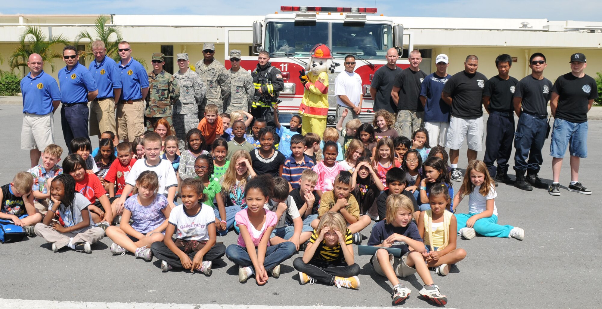 Students from Kadena Elementary School along with base firefighters join in a photo opportunity after Sparky the Fire Dog is promoted to staff sergeant in a ceremony at Kadena Oct. 7. Sparky has promoted fire safety across Kadena since 1988. (U.S. Air Force photo by Tech. Sgt. Mike Tateishi)