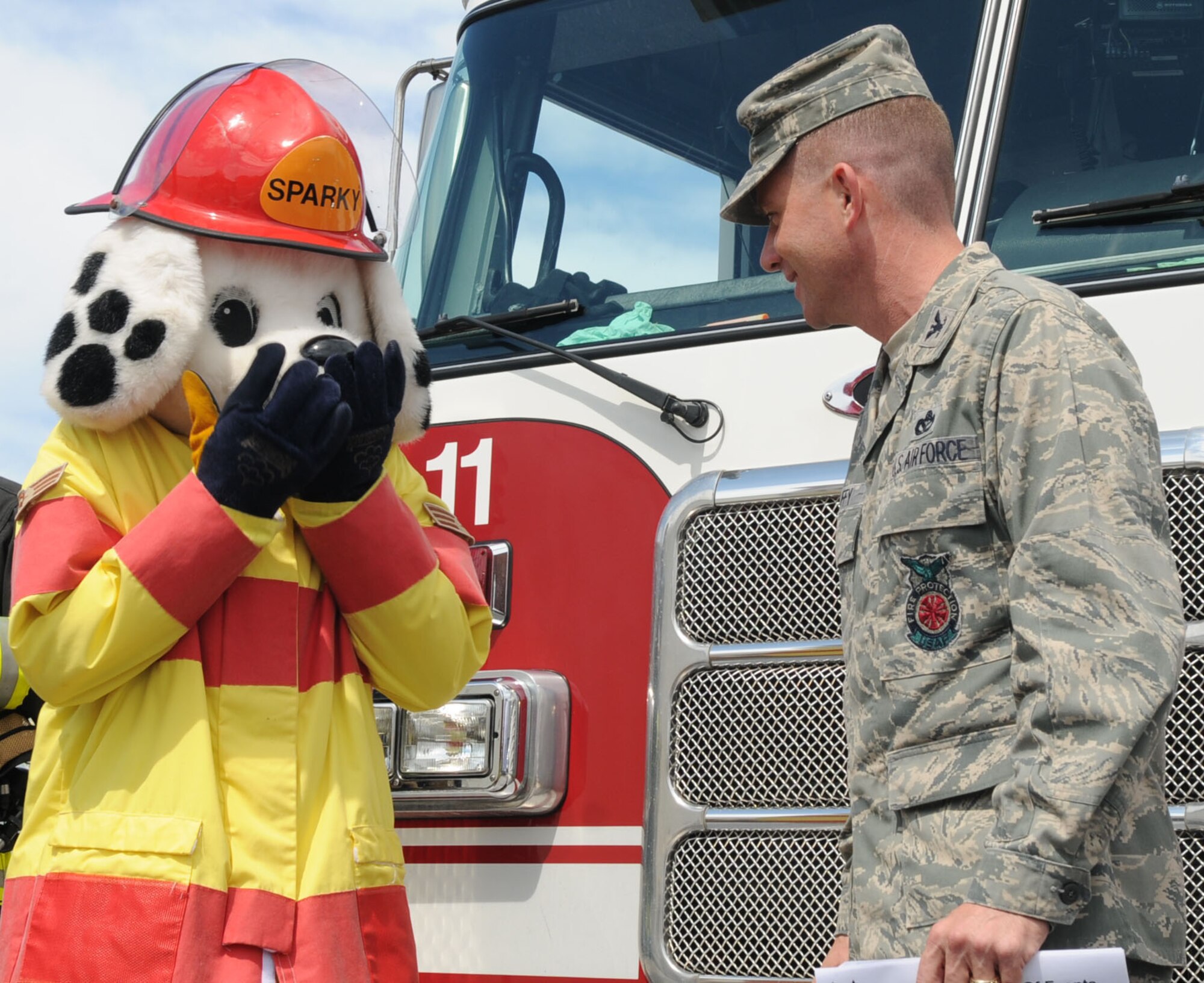 Sparky The Fire Dog reacts to the news he’s being STEP (Stripes For Exceptional Performers) promoted to staff sergeant by Col. Brian Duffy, 18th Civil Engineer Group commander in a ceremony at Kadena Elementary School, Oct. 7. Sparky's new title is NCOIC of Fire Prevention Public Information.  (U.S. Air Force photo by Tech. Sgt. Mike Tateishi)