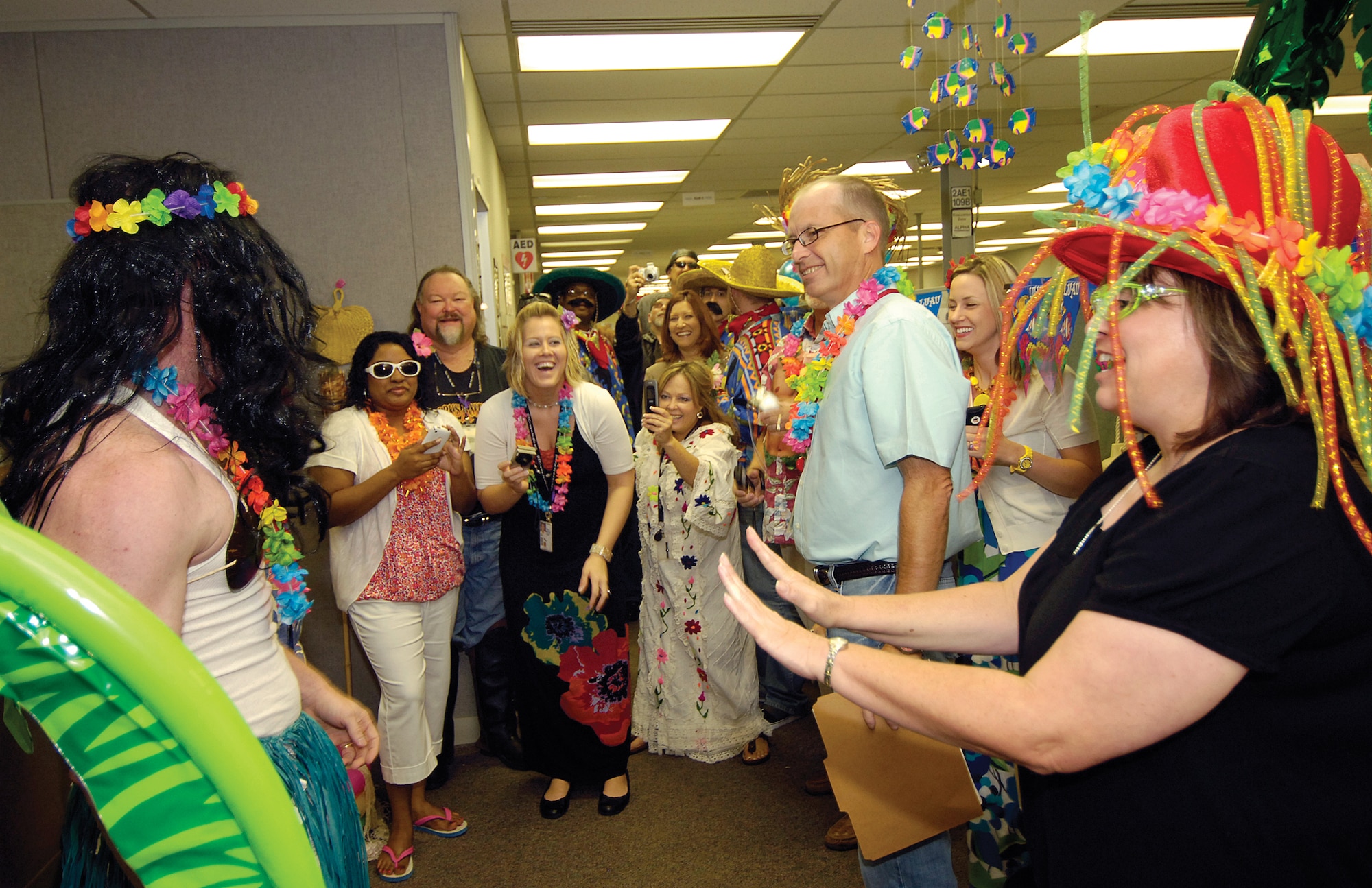 Beating the stress of a looming fiscal year end all-nighter and boosting morale was a competition between the five branches of Defense Logistics Agency Aviation at Oklahoma City, located in Bldg. 3001. Costumed employees and judges, director Frances Evans and deputy director Rick Vincent, far right, enjoyed James Chandler’s hula dance at the luau area during judging. Branches decorated, dressed up and provided theme-based food to win bragging rights. Besides a luau theme, branches turned their areas into a New Year’s Eve party, a Mardi Gras parade, a fiesta celebration and leather-wearing bikers hangout. Ms. Evans and Mr. Vincent were impressed with the creativity, effort and enthusiasm in the stress-breaker. “They work hard all year,” said Mr. Vincent. “The lengths these guys go to in support of the war fighter is phenomenal, and they come through every year. They will obligate $800 million in depot-level spare parts for fiscal year 2010.” New Year’s Eve was the overall winner, but Ms. Evans declared all the branches winners. Soon, the food was eaten, costumes were off and it was back to business and a late night for the 63 member organization. (Air Force photo by Margo Wright)
