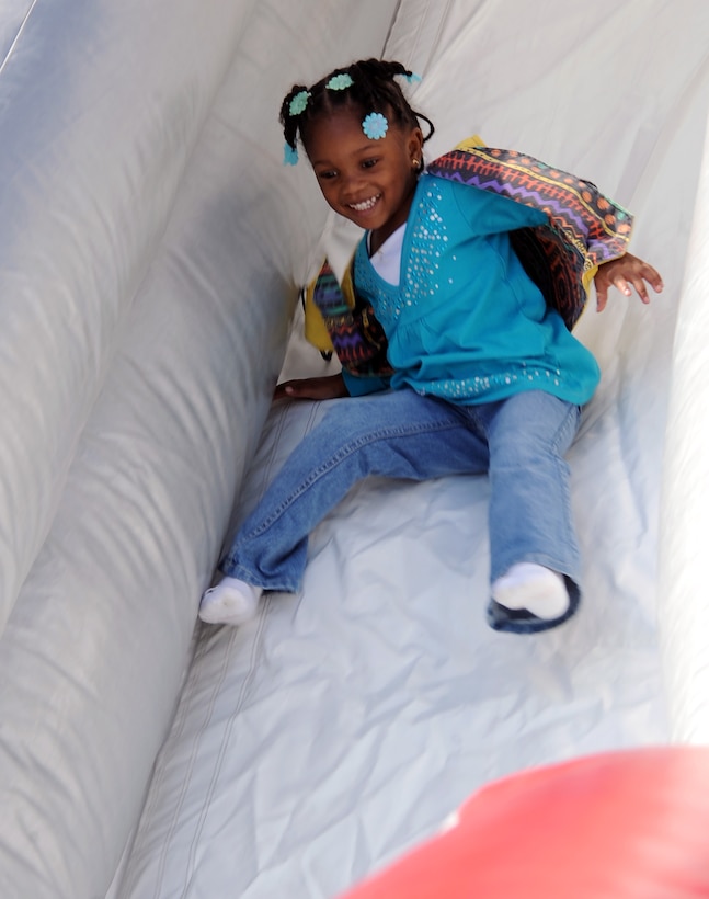 LANGLEY AIR FORCE BASE, Va. – Dajaj Lucas, daughter of Natalie Lucas, slides down a slide after learning fire safety from Sparky the fire dog Oct. 7. Base firefighters are teaching children about fire safety during Fire Prevention Week, Oct. 3-9.  Events and activities promoting fire safety and prevention culminate in a fire department open house. (U.S. Air Force photo/Staff Sgt. Tabitha Kuykendall) (released)