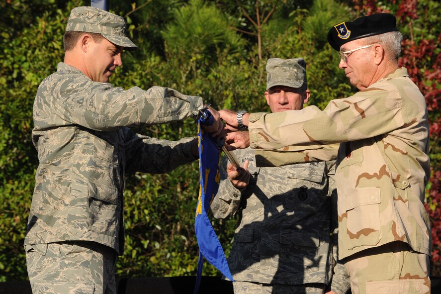 MOODY AIR FORCE BASE, Ga. -- Col. John Horner, 93rd Air Ground Operations Wing commander, rolls up the 820th Security Forces Group flag with retired Brig. Gen. Richard Coleman during the 820th Base Defense Group redesignation ceremony here Oct. 7. A new guidon was presented to Colonel Horner with the new 820th BDG flag attached. (U.S. Air Force photo/Airman 1st Class Benjamin Wiseman)