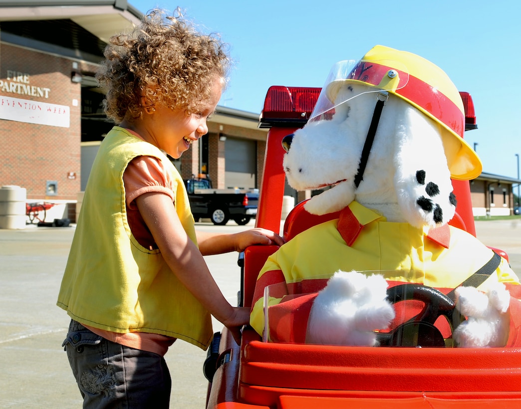 LANGLEY AIR FORCE BASE, Va. – Annabella Esquilin, daughter of Katherine Gielinin, learns about fire safety from Sparky the fire dog Oct. 7. Base firefighters are teaching children about fire safety during Fire Prevention Week, Oct. 3-9.  Events and activities promoting fire safety and prevention culminate in a fire department open house. (U.S. Air Force photo/Staff Sgt. Tabitha Kuykendall) (released)