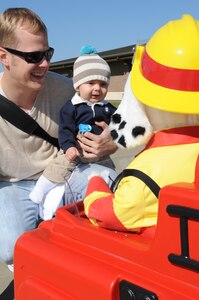 LANGLEY AIR FORCE BASE, Va. – Benjamin Hoffman with father Peter Hoffman, listen to fire safety tips from Sparky the fire dog Oct. 7. Base firefighters are teaching children about fire safety during Fire Prevention Week, Oct. 3-9.  Events and activities promoting fire safety and prevention culminate in a fire department open house. (U.S. Air Force photo/Staff Sgt. Tabitha Kuykendall) (released)