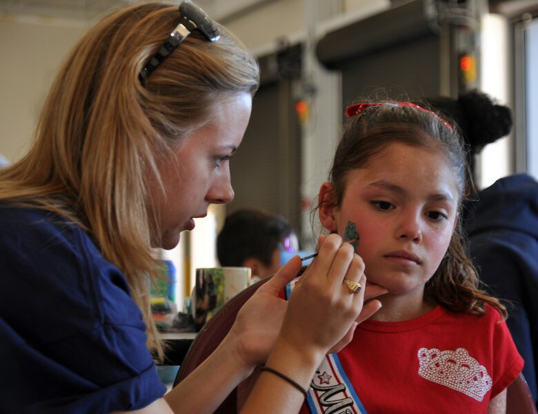 Second Lt. Sara Greco, 14th Mission Support Group and Fire Prevention Week Open House volunteer, paints the face of a young attendee at the event Oct. 2. (U.S. Air Force photo/Airman 1st Class Chase Hedrick).