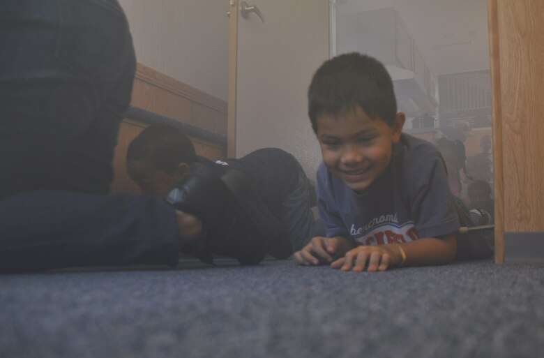 Manuel Keomanila, son of Master Sgt. Chin Keomanila, crawls through a room filled with fake smoke designed to teach people what to do in a fire, during 2010 Fire Prevention Week Open House Oct. 2. (U.S. Air Force photo/Airman 1st Class Chase Hedrick). 