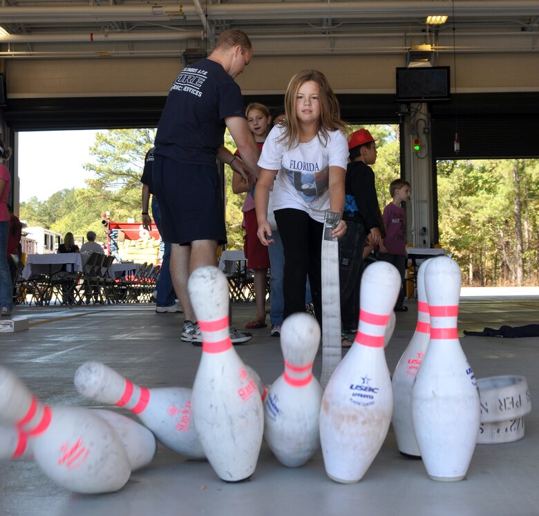 Alyssa Franks, daughter of Staff Sgt. Bryan Franks, knocks over pins while bowling with a fire hose at the 2010 Fire Prevention Week Open House Oct. 2.(U.S. Air Force photo/Airman 1st Class Chase Hedrick)