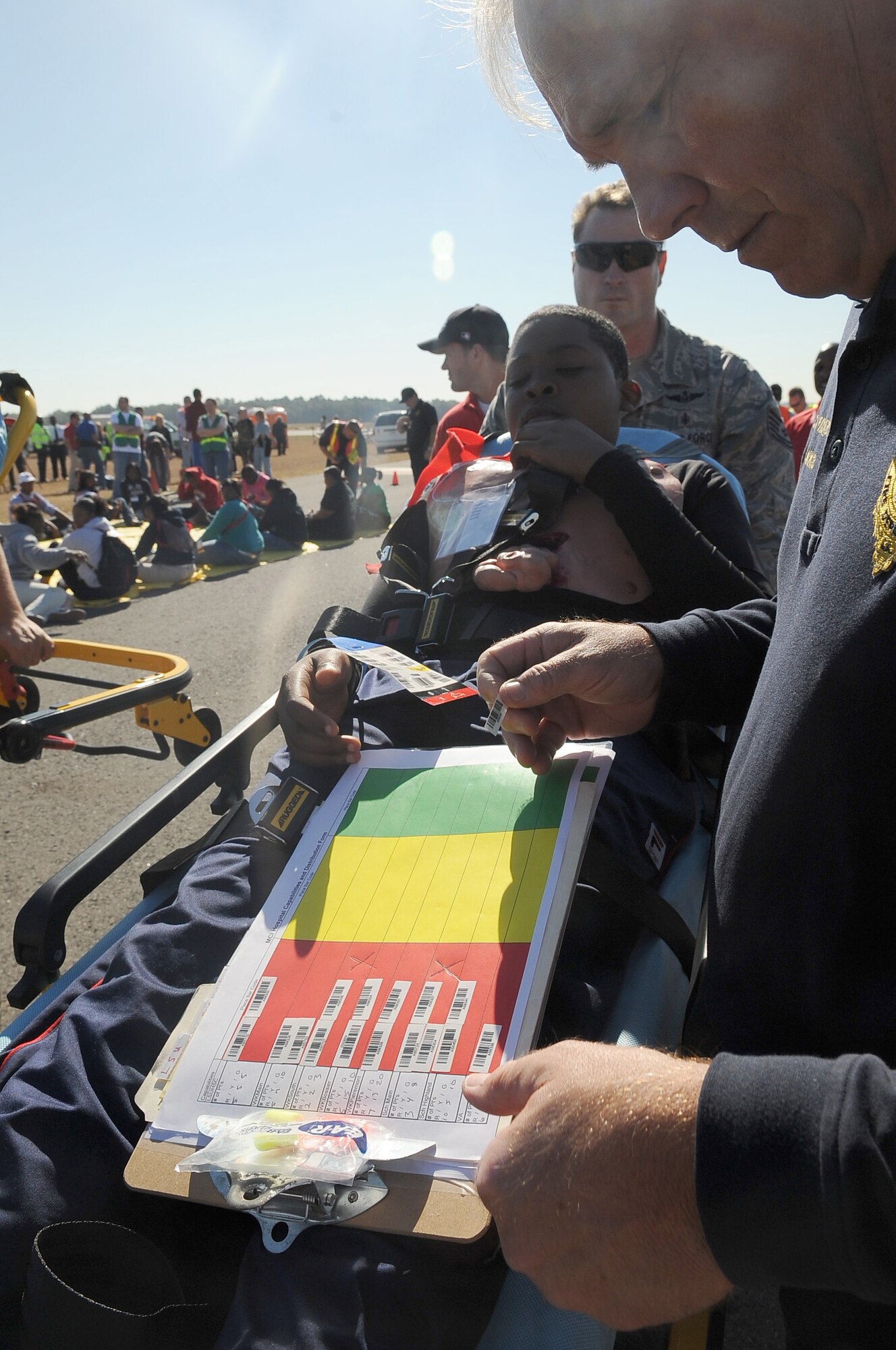 BARKSDALE AIR FORCE BASE, La. -- A Shreveport Fire technician checks a victim's information tag during a full-scale disaster drill at the Shreveport Regional airport Oct. 6. More than 60 simulated victims were either listed as deceased or injured and Bossier City, Shreveport and Caddo law enforcement, fire department and emergency medical technicians arrived on scene to assist. The exercise provided training and an opportunity for Barksdale Airmen to work with other emergency units.  (U.S. Air Force photo/Senior Airman Amber Ashcraft) (RELEASED)