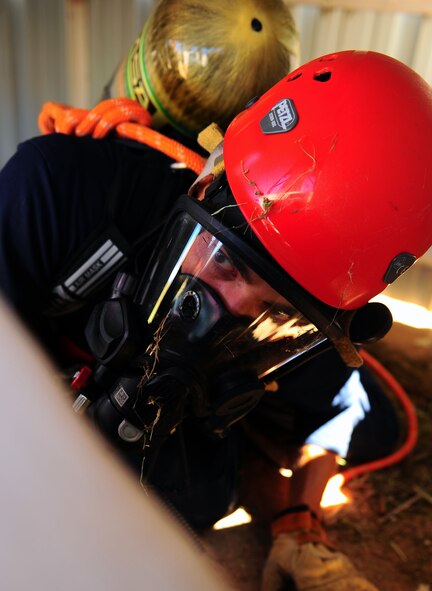 DYESS AIR FORCE BASE, Texas -- Airman 1st Class Anthony Guajardo, 7th Civil Engineer firefighter, searches in a tunnel looking for his partner during a retrieval training exercise at Dyess Air Force Base, Oct. 6. Several firefighters gathered on training grounds located just off the flightline to conduct rescue or retrieval training in confined spaces. (U.S. Air Force photo/ Senior Airman Domonique Washington) 
