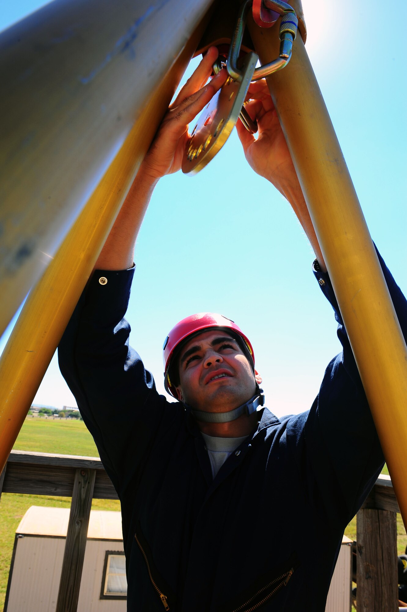 DYESS AIR FORCE BASE, Texas—Airman 1st Class Anthony Guajardo, 7th Civil Engineer firefighter, assembles a tripod used for propelling and hauling here Oct. 6. The tripod is checked three times for safety before it is used to propel or haul anyone.  Airman Guajardo along with others gathered at the training grounds to conduct rescue or retrieval training in confined spaces. These emergency responders can be called to situations that require climbing or propelling into small spaces, to retrieve the bodies of dead or injured people, due to the hazards of ditches or uncontrolled working areas. (U.S. Air Force photo/ Senior Airman Domonique Washington)