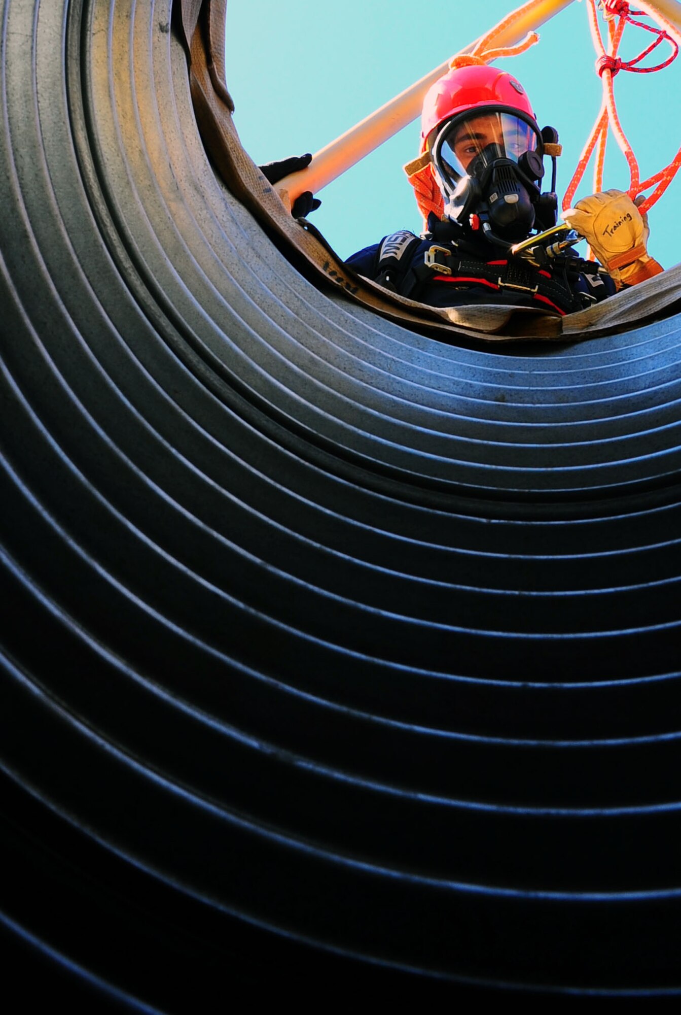 DYESS AIR FORCE BASE, Texas—Airman 1st Class Anthony Guajardo, 7th Civil Engineer firefighter, peers down a dark tunnel here Oct. 6. Several firefighters gathered at the training grounds located just off the flightline to conduct rescue and retrieval training in confined spaces.  These emergency responders can be called to situations that require climbing or propelling into small spaces, to retrieve the bodies of dead or injured people, due to the hazards of ditches or uncontrolled working areas. (U.S. Air Force photo/ Senior Airman Domonique Washington)