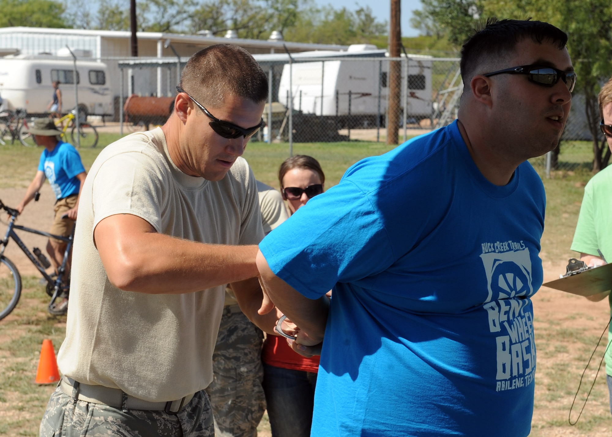 ABILENE, Texas—Staff Sgt. Mark Sagvold (left), 7th Security Forces Squadron bike patrol, arrests an individual as a obstacle during the 3rd annual Gun-N-Hoses Competition at the Warren Dodson Training Facility here, Oct. 2. The competition is a way for Dyess Airmen to interact with the Abilene community. Abilene firefighters, police officers and Dyess’ security forces Airmen competed against one another in a friendly competition of skills that included a hose pull, dummy drag and pistol shooting. (U.S. Air Force photo/ Senior Airman Felicia Juenke)
