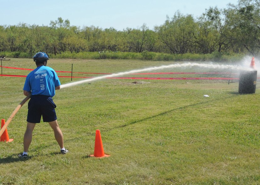 ABILENE, Texas-- Stan Standridge, Abilene police chief, uses a fire hose to knock down a cone during the 3rd annual Gun-N-Hoses Competition at the Warren Dodson Training Facility here, Oct. 2. The competition is a way for Dyess Airmen to interact with the Abilene community. Abilene firefighters, police officers and Dyess’ Security Forces Airmen competed against one another in a friendly competition of skills that included a hose pull, dummy drag and pistol shooting. (U.S. Air Force photo/ Senior Airman Felicia Juenke)