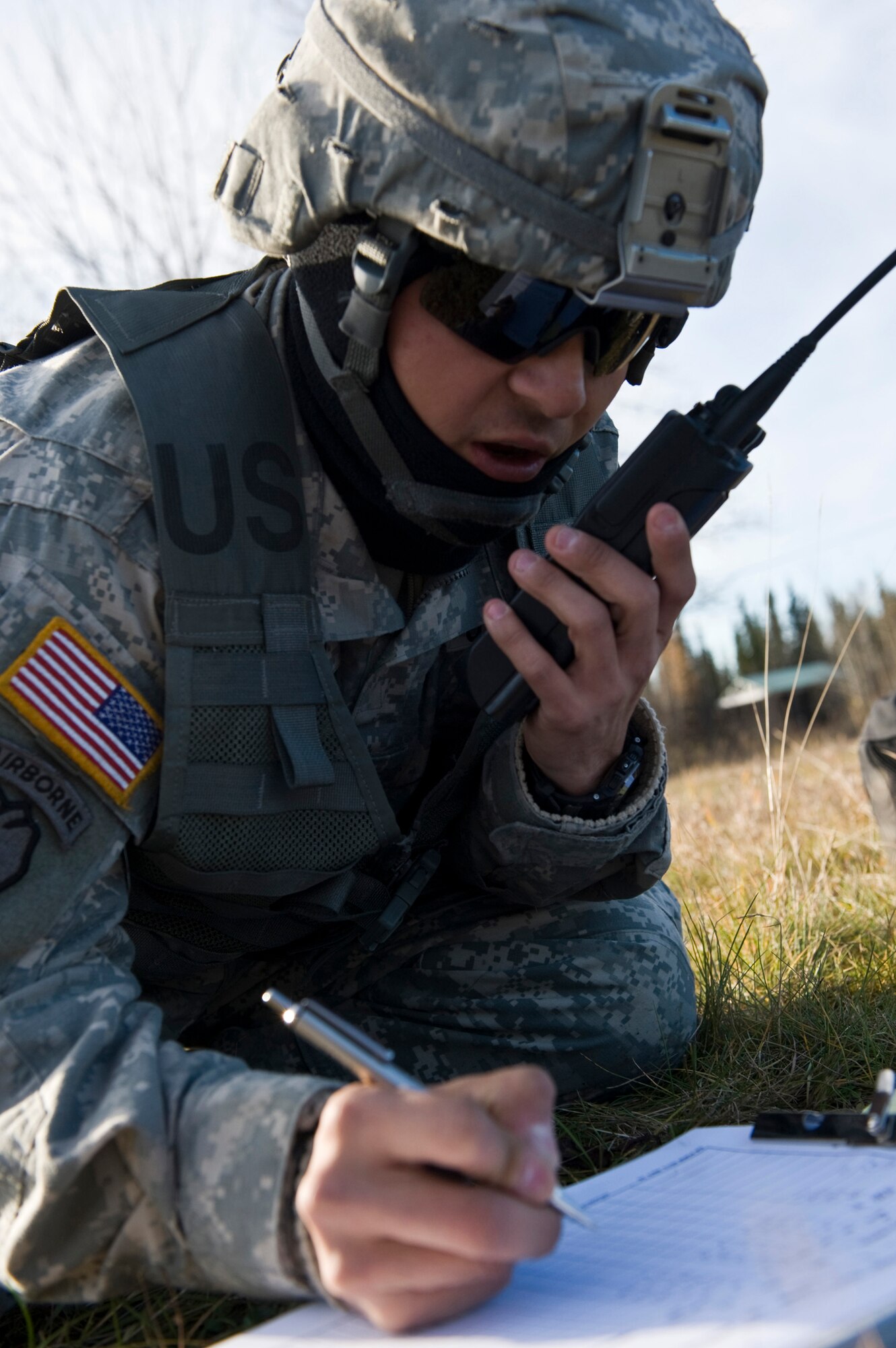 JOINT BASE ELMENDORF-RICHARDSON, Alaska -- Spc. John Martinez ammunition team chief of the 1st Section of the Alpha Battery from the 2nd Battalion of the 377th Parachute Field Artillery Regiment communicates over a radio Oct. 5, Spc. Martinez is responsible for tracking and recording ammunition being used. Members of the 2-377th PFAR simulated a two-gun raid, firing into "enemy territory," as part of some mission-ready training. They used M119 105 mm howitzers which were sling loaded to the Black Hawk as part of the training. (U.S. Air Force photo/Airman 1st Class Christopher Gross)  