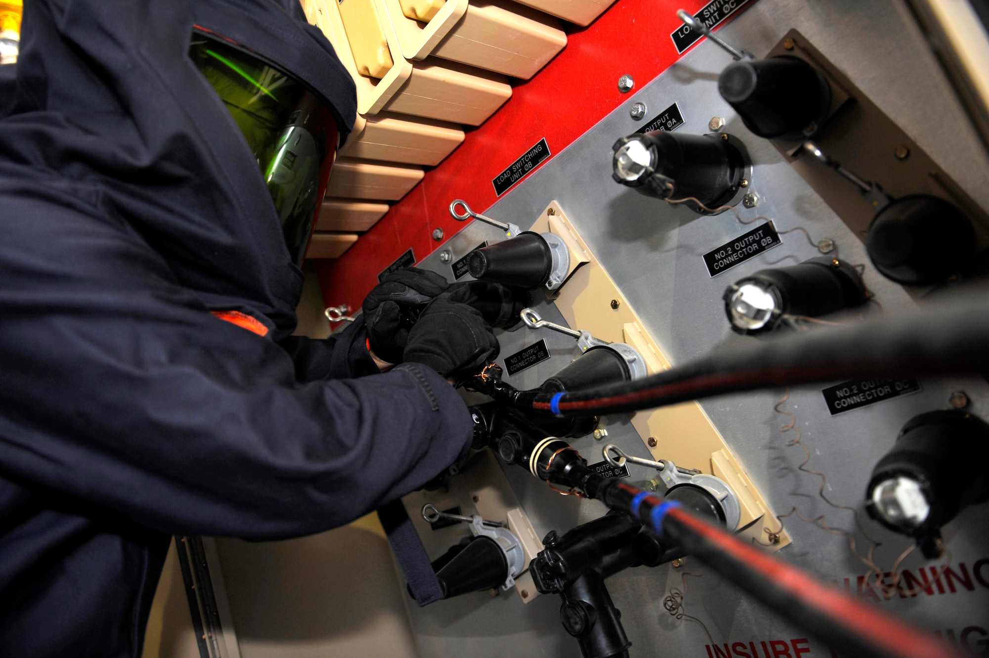 HOLLOMAN AIR FORCE BASE, N.M. -- Airman 1st Class Jamie Peterson, 49th Materiel Maintenance Squadron, hooks up a high-voltage connector to test the electrical voltage of a secondary distribution center Sept. 30, 2010. These secondary distribution centers transform 12,470/7,200 volts down to a useable 120/208 volts that powers tents, shop equipment and personal utilities in a deployed location. Electricians from the Basic Expeditionary Airfield Resource base perform maintenance tests on secondary distribution centers, primary switching centers and remote area lighting systems to ensure they are functional in military installations downrange. (U.S. Air Force photo by Senior Airman Veronica Stamps / Released)