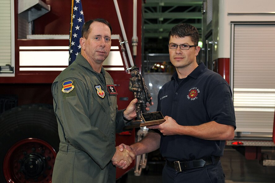 OFFUTT AIR FORCE BASE, Neb. -- Brigadier Gen. John N.T. Shanahan, 55th Wing commander, presents Matthew Gibbons, a member of the 55th Civil Engineering Squadron, with the fire fighter of the year award during a ceremony in the Offutt Fire Station Oct. 7. Each year the award of fire fighter and fire officer of the year are presented during Fire Prevention Week. U.S. Air Force photo by Charles Haymond