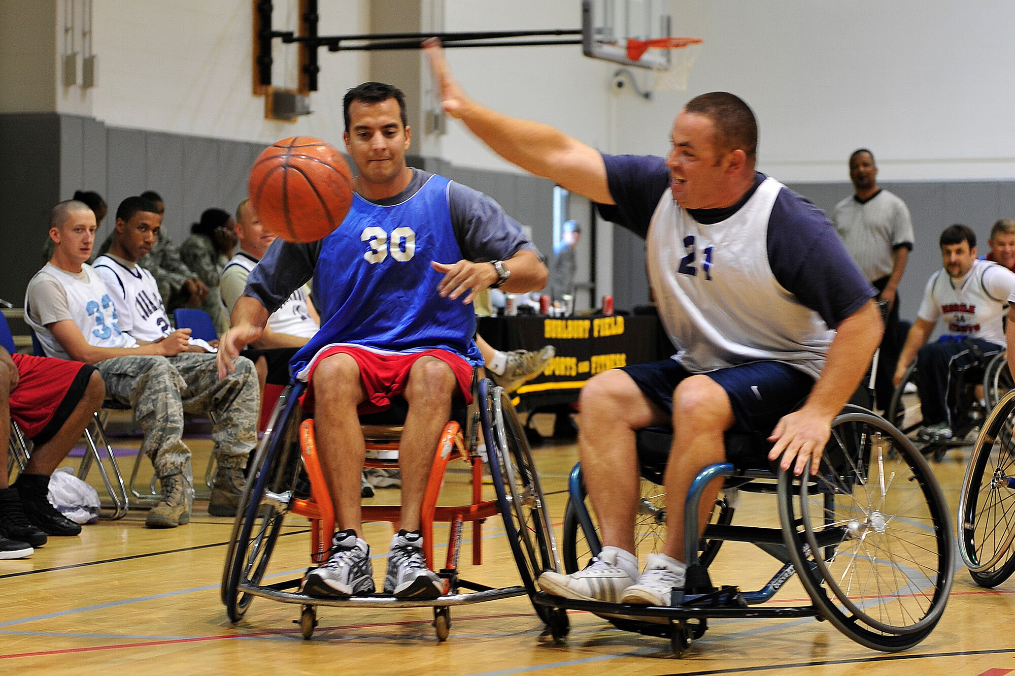 U.S. Air Force Major Adonis Arvanitakis (left), 19th Special Operations Squadron, throws the ball to a team member while Master Sgt. Rocco DiGiorgio, 11th Intelligence Squadron, tries to block during the fifth annual Wheelchair Basketball Exhibition Game at the Aderholt Fitness Center at Hurlburt Field, Fla., Oct. 4, 2010. The Air Commandos hosted the Mobile Patriots, a Gulf Coast division three National Wheelchair Basketball Association team, in recognition of National Disability Employment Awareness month. (DoD photo by U.S. Air Force Staff Sgt. Stephanie Jacobs/RELEASED)

